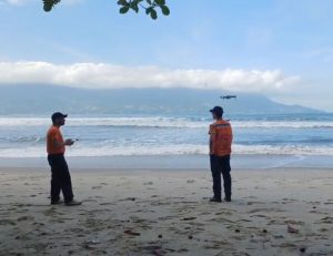 Buscas por Bruno Barreto Otsu em São Sebastião contam com drones, helicóptero Águia e apoio do GBMar A Defesa Civil de São Sebastião reforçou as buscas por Bruno Barreto Otsu, de 21 anos, desaparecido desde a última segunda-feira (11) após entrar no mar na costeira da praia de Toque-Toque Grande, na Costa Sul do município. A operação passou a contar com drones para monitoramento aéreo em áreas de difícil acesso. Para ampliar a área de monitoramento, a Defesa Civil passou a utilizar drones durante a operação. O equipamento permite alcançar pontos de difícil acesso, principalmente em locais atingidos por fortes ondas e mar agitado, onde a aproximação por terra ou embarcações é limitada. Segundo a Defesa Civil, a tecnologia auxilia no aumento do campo de visão das equipes e possibilita uma cobertura mais ampla da área marítima. O coordenador municipal da Defesa Civil, Ricardo Cardoso dos Santos, afirmou que o trabalho ocorre de forma integrada com outras forças de segurança e resgate da região. “Temos equipes preparadas, equipamentos e embarcações que podem contribuir nas buscas tanto pelo mar quanto nas costeiras. Estamos empenhados em apoiar todas as frentes da operação e esperamos que em breve possamos ter alguma notícia sobre o jovem”, declarou. Além das equipes terrestres e marítimas, a Polícia Militar também utiliza o Helicóptero Águia nas buscas aéreas pela região. De acordo com informações apuradas pelas equipes de resgate, Bruno entrou no mar para tentar salvar Maria Eduarda, também de 21 anos, após a jovem ser arrastada por uma onda enquanto caminhava pela costeira de Toque-Toque Grande. Maria Eduarda foi levada pela correnteza e encontrada cerca de cinco horas depois nas proximidades da praia de Barequeçaba, a aproximadamente cinco quilômetros do local inicial. Ela foi resgatada por um pescador que seguia em direção a Santos e acionou o Corpo de Bombeiros. Segundo relato prestado pela jovem aos bombeiros marítimos, Bruno não foi atingido diretamente pela onda, mas entrou na água na tentativa de ajudá-la e desapareceu em seguida. Familiares de Bruno Barreto Otsu também mobilizam campanhas nas redes sociais em busca de apoio voluntário para auxiliar nas buscas. Os pedidos envolvem proprietários de embarcações, mergulhadores e operadores de drones.