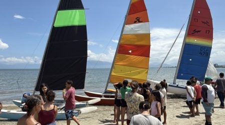 Projeto Colônia de Férias leva crianças de Caraguatatuba para experiência de velejar e educação ambiental.