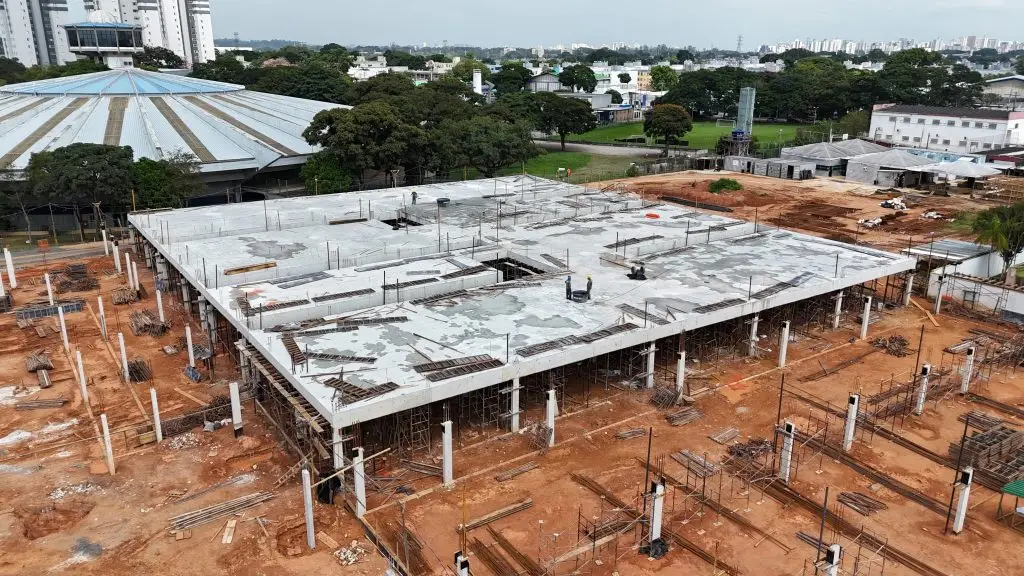 Obras da maternidade em São José dos Campos avançam com 90% da fundação concluída; unidade terá 150 leitos e atendimento regional A cidade de São José dos Campos está investindo em um novo hospital materno-infantil. A administração municipal informou que 90% da fundação da nova unidade está concluída e a obra segue em ritmo acelerado. O hospital está sendo construído na Vila Industrial, região leste da cidade, e deve ampliar o atendimento materno-infantil na cidade e região. De acordo com a prefeitura de São José dos Campos, os pilares da estrutura atingiram aproximadamente 85% de execução, enquanto as vigas e lajes estão em torno de 25%. Estrutura do novo hospital A nova maternidade está sendo construída na rua Ricardo Edwards, ao lado do Teatrão, e terá 150 leitos. O empreendimento ocupará uma área total de 18,6 mil metros quadrados, incluindo edificação, paisagismo e estacionamento. Para otimizar o andamento, a obra foi dividida em quatro setores (A, B, C e D), permitindo a execução simultânea das etapas. Atualmente, os trabalhos estão concentrados na montagem de escoramentos e fôrmas no Setor B, etapa necessária para a próxima concretagem. Também já teve início o fechamento da platibanda no Setor A, indicando avanço nas estruturas superiores. Próximas etapas Entre as próximas fases previstas estão: Concretagem da laje do Setor B Início da montagem estrutural do Setor C Implantação das infraestruturas hidráulicas no Setor A Atendimento e serviços A prefeitura ainda destacou que a unidade foi planejada com foco no atendimento integral à saúde da mulher e da criança. Entre os serviços previstos estão: Mais de 100 leitos de internação UTIs materna e neonatal Atendimento ambulatorial e pronto atendimento obstétrico Centro obstétrico completo (pré-parto, parto e puerpério) Casa de apoio para gestantes e bebês de alto risco Ordem de serviço assinada em setembro de 2025 A maternidade começou a sair do papel em setembro de 2025 com a assinatura da ordem de serviço. O investimento do hospital está estimado em R$ 77 milhões, com previsão de entrega em 2027. A área onde está sendo construída a nova maternidade pertencia ao São José EC, que, por meio de uma permuta, cedeu o local à prefeitura para a construção do hospital.
